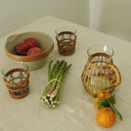 Be Home Seagrass rattan wide cage tumbler in hand-woven rattan over glass, styled in a room setting