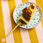 Bitossi Home Torchon gold cake server with twisted handle, 27.5cm, styled in a table setting